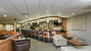 A hotel lobby with a bar area, seating arrangements, and a television mounted on the wall. - Wyndham Garden Fresno Yosemite Airport (Fresno)