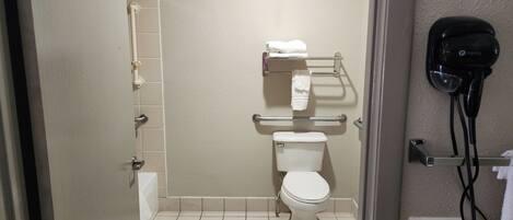 A bathroom with a toilet, a towel rack, and a hand dryer.