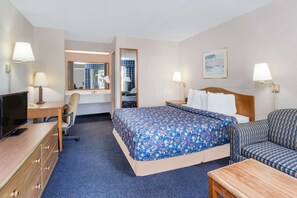 Relax in a spacious room with a large bed, desk, and comfortable armchair.