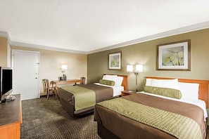 A hotel room with two beds, a desk, a chair, a TV, and artwork on the walls. - Baymont by Wyndham San Antonio Near South Texas Medical Ctr (San Antonio)