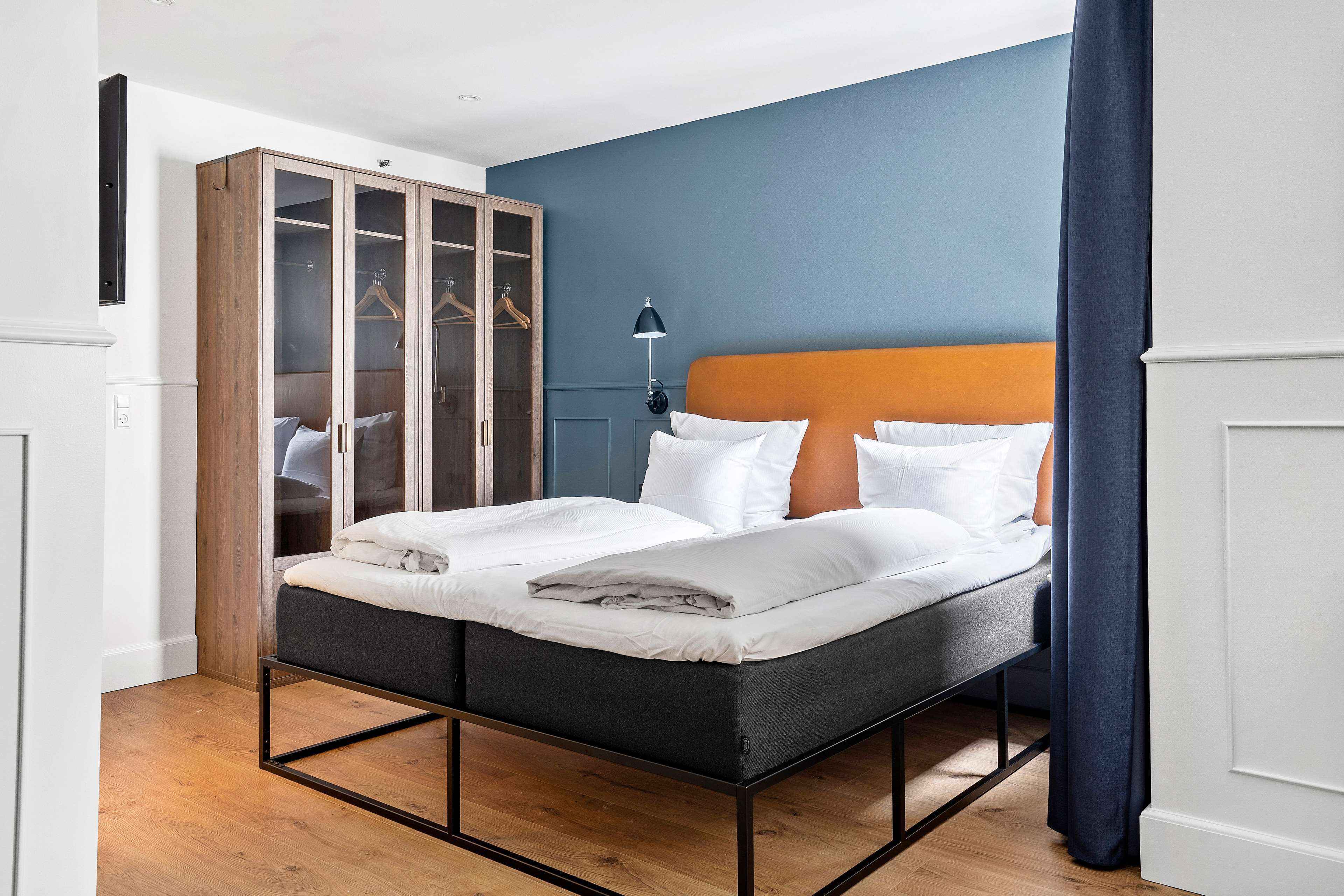 A bedroom with a bed, wardrobe, and a lamp.