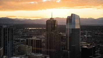A cityscape with modern skyscrapers and a mountain range in the background.
