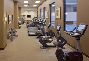 A hotel gym with multiple exercise machines, including treadmills and stationary bikes, arranged in a row. - Grand Hyatt Denver (Denver)