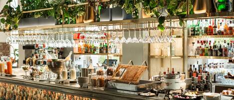 Eine Bar mit Regalen voller Flaschen, Gläsern und verschiedenen Speisen.