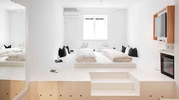A modern bedroom with a built-in bed, a television, and a fireplace.
