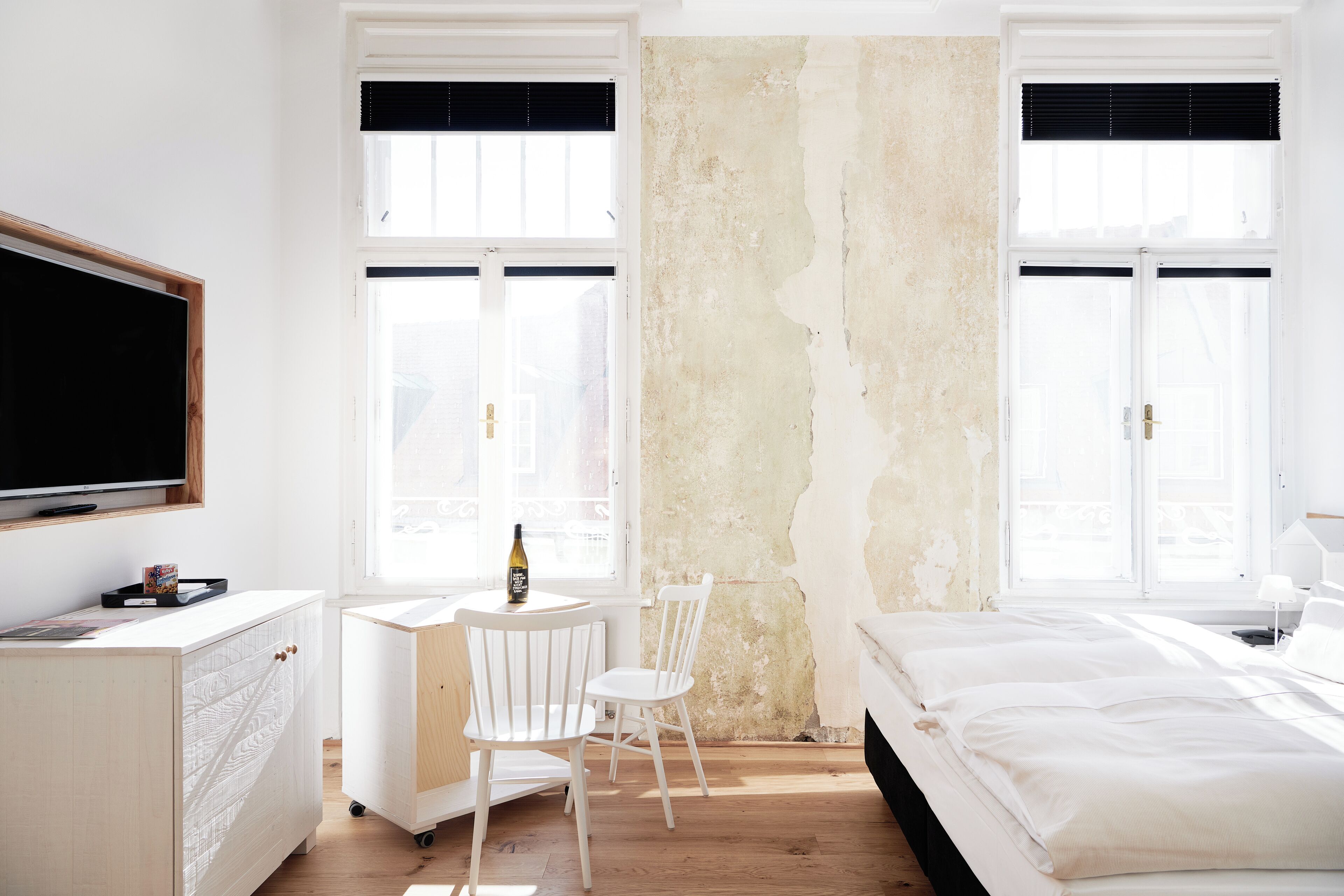 Une chambre à coucher comprenant un lit, un bureau, une chaise et un téléviseur.