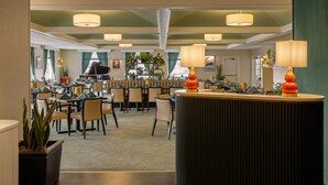 Eine Hotelhalle mit Empfangstresen, Sitzgelegenheiten und einem Klavier.
