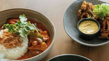 A table with three bowls of food, each with different sauces and garnishes.
