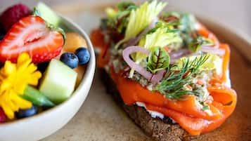 A sandwich with smoked salmon, cream cheese, and vegetables on a slice of bread.