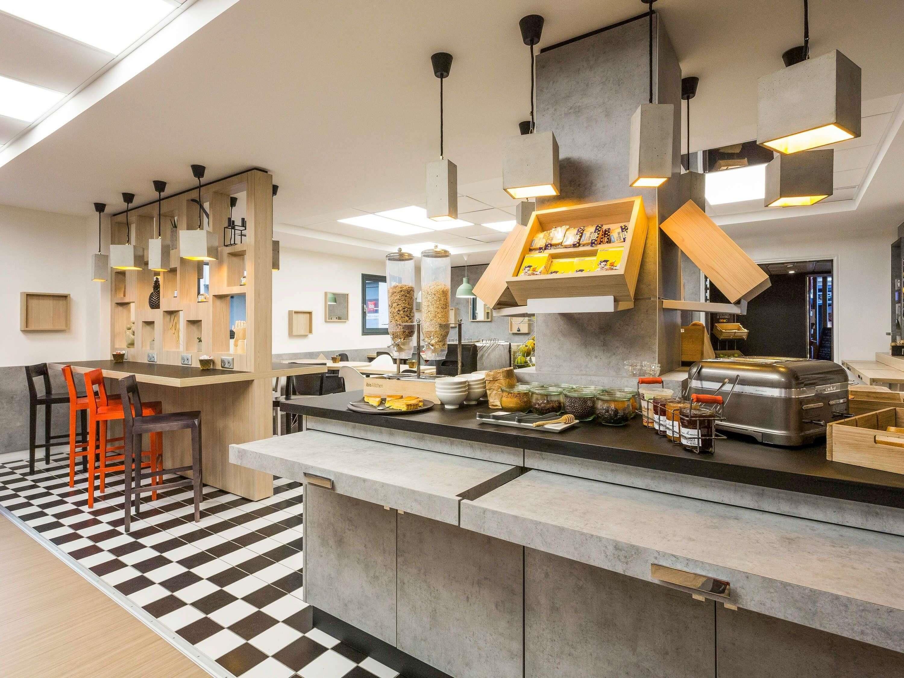 Eine moderne Küche mit Bar, Schachbrettboden und Grillstation.