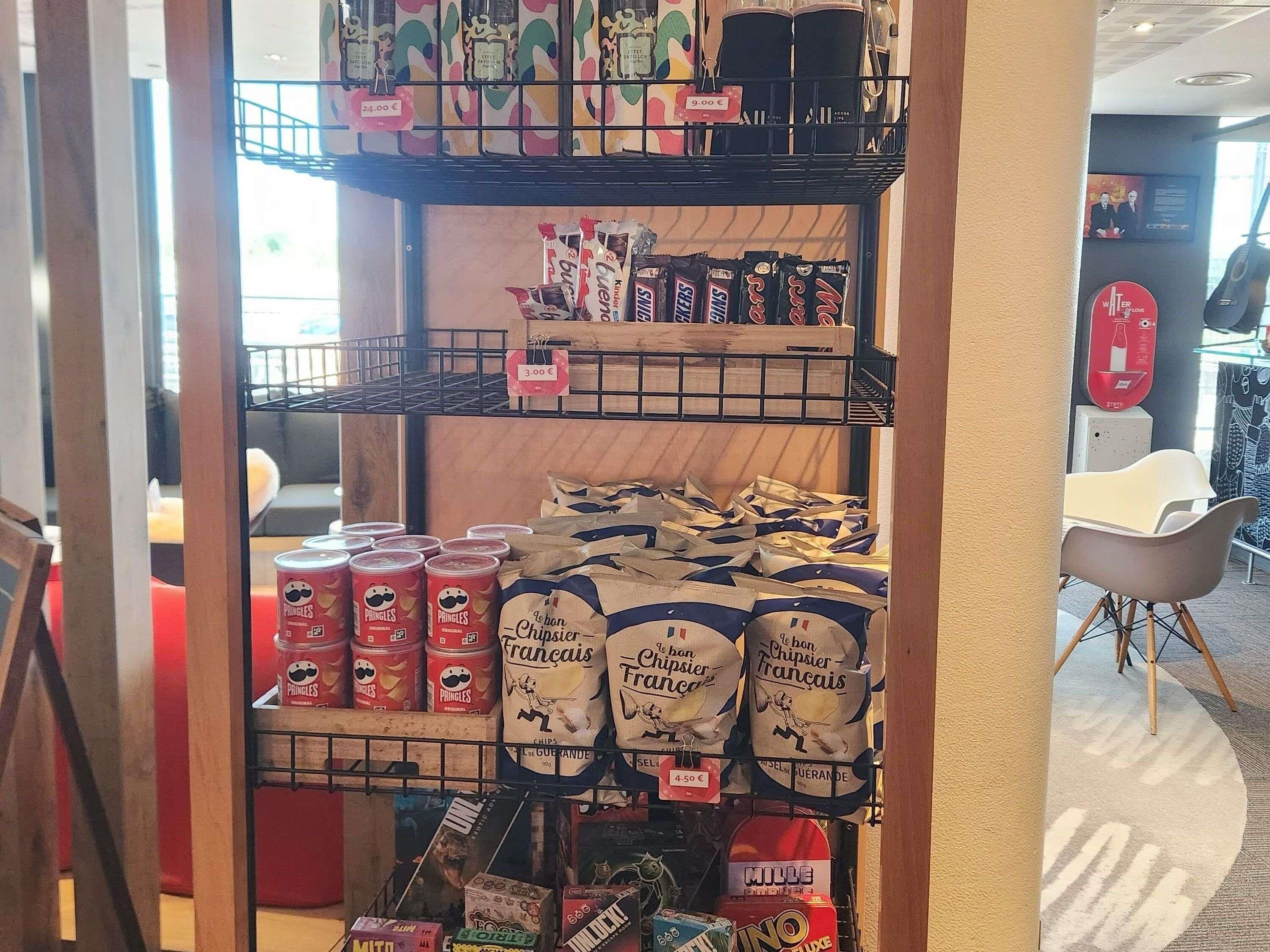 A snack display with Pringles, chips, and other packaged snacks.