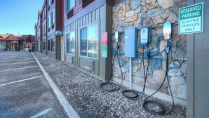 A parking lot with electric vehicle charging stations and a reserved parking sign. - Holiday Inn West Yellowstone by IHG. (West Yellowstone)