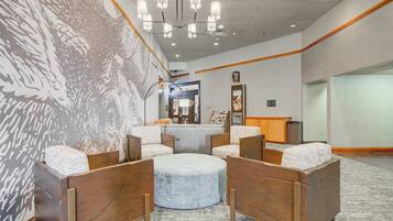 Relax in the stylish lobby with a comfortable seating area featuring a round ottoman and armchairs.