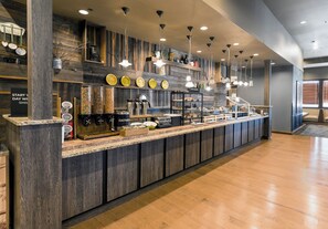 A breakfast bar with a coffee machine, toaster, and various food items. - Holiday Inn West Yellowstone by IHG. (West Yellowstone)