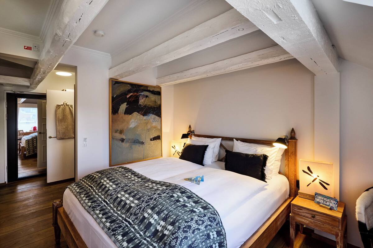 Un dormitorio con una cama grande, cabecera de madera y un cuadro en la pared.