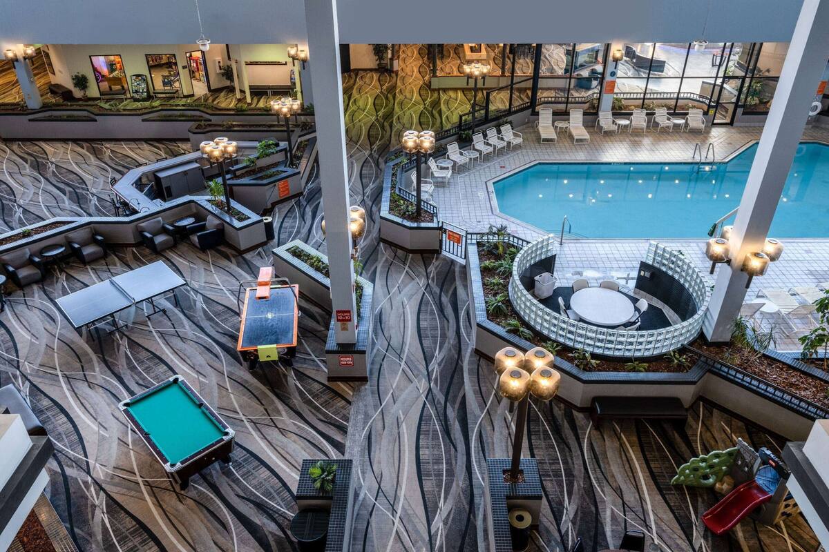 A poolside area with lounge chairs, a pool, and a billiards table.