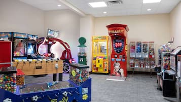An indoor arcade with various gaming machines, including a soccer table and a basketball shooting game.