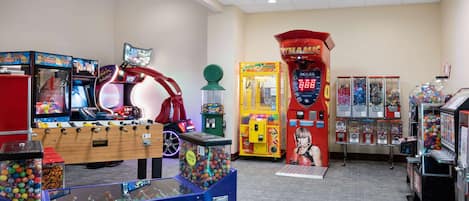 Una sala d'arcade interior amb diverses màquines de jocs, incloent-hi un futbolí i un joc de tir a cestes.