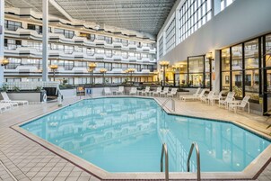 Una piscina interior con varios niveles de balcones, sillas de descanso y un diseño arquitectónico moderno.