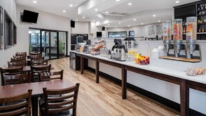 Un restaurante moderno con una barra alargada, sillas de madera y una variedad de alimentos a la vista.