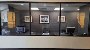 A reception area with a glass partition, framed pictures on the wall, and two HP computers on desks.