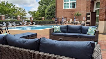 Una piscina al aire libre, sombrillas, sillones reclinables de piscina