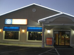 A building with a sign that reads "KARMA'S" and a blue awning over the entrance.