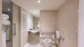 A modern bathroom with a toilet, sink, and glass shower enclosure.