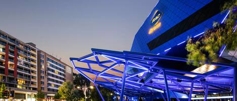 A modern building with a distinctive blue roof structure and a visible logo.