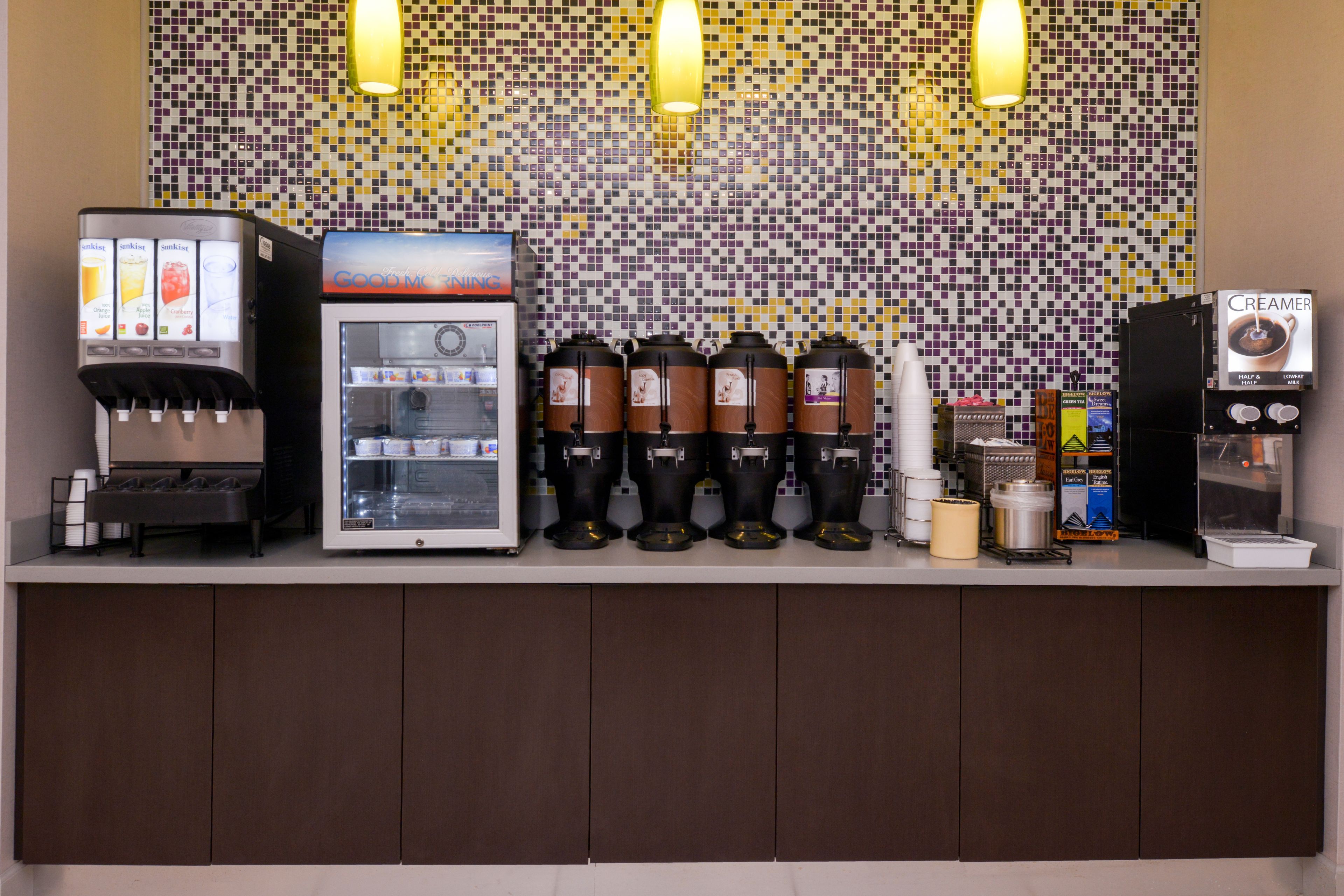 Un espace dédié au café, équipé d’une machine à café, de plusieurs distributeurs de café et d’un distributeur de crème.