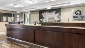 A hotel reception desk with a modern design, a large logo, and a map on the wall. - Quality Inn & Suites North Charleston - Ashley Phosphate (North Charleston)