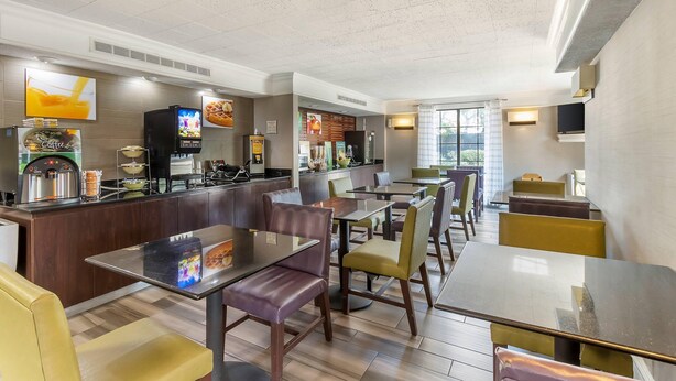 A modern restaurant with a bar area, seating, and a coffee machine. - Quality Inn & Suites North Charleston - Ashley Phosphate (North Charleston)