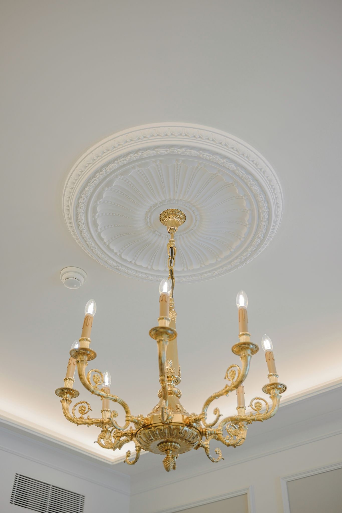 A chandelier with multiple arms and candle-like lights.