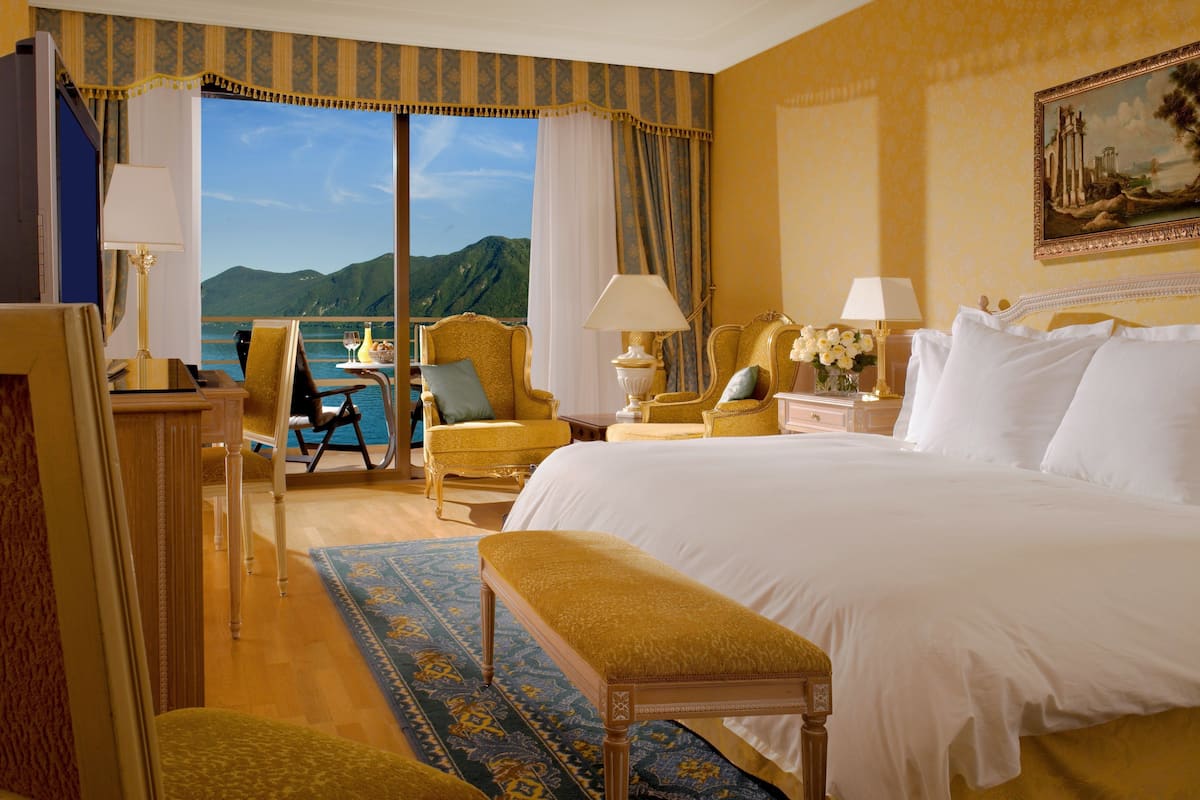 Una habitación de hotel con una cama grande, un escritorio, una silla y vistas al mar.