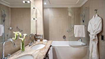 Un baño moderno con dos lavamanos, una bañera y un box de ducha de vidrio.