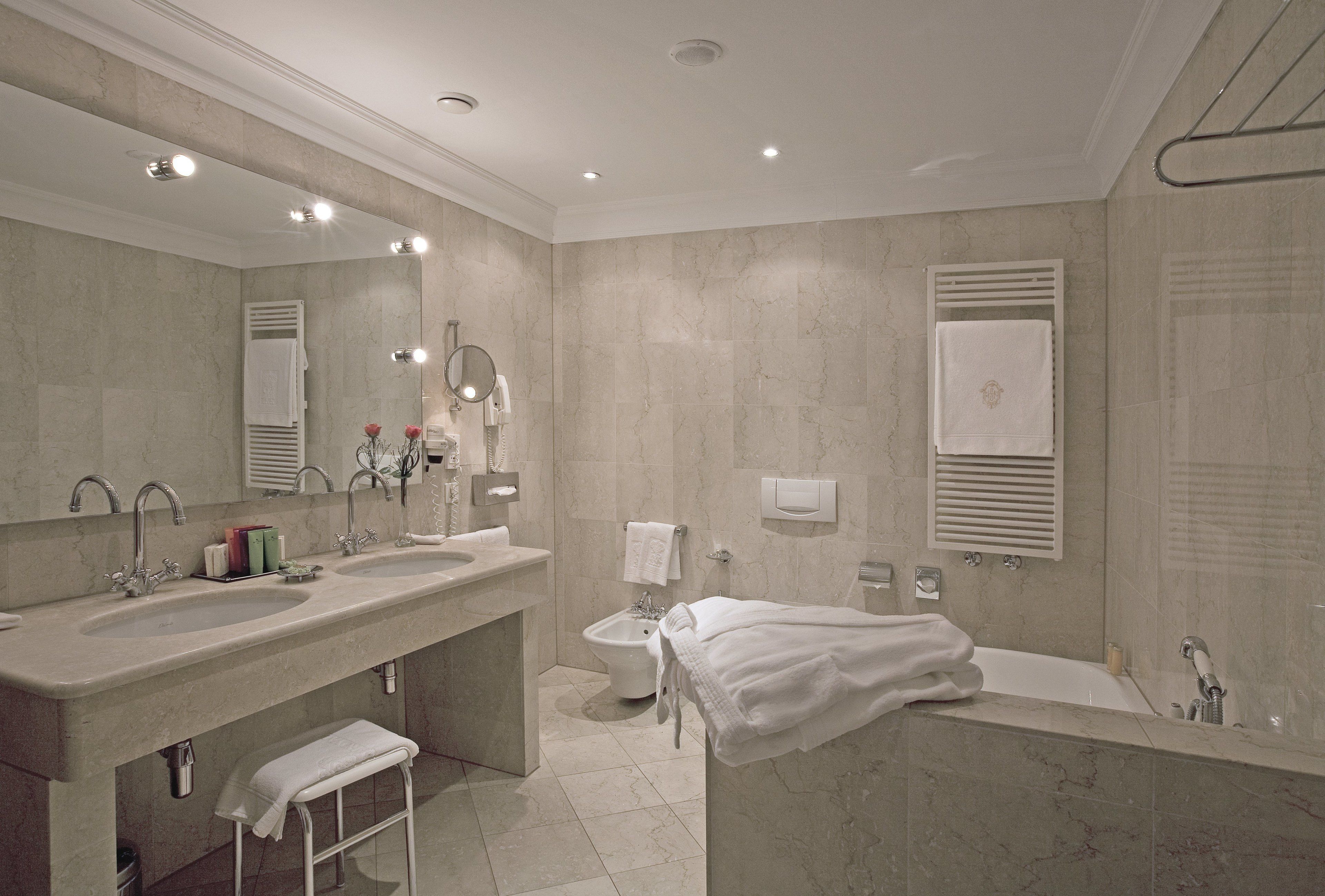 Un baño moderno con dos lavamanos, un bidé y una bañera.