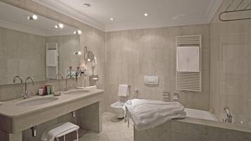 Un baño moderno con dos lavamanos, un bidé y una bañera.
