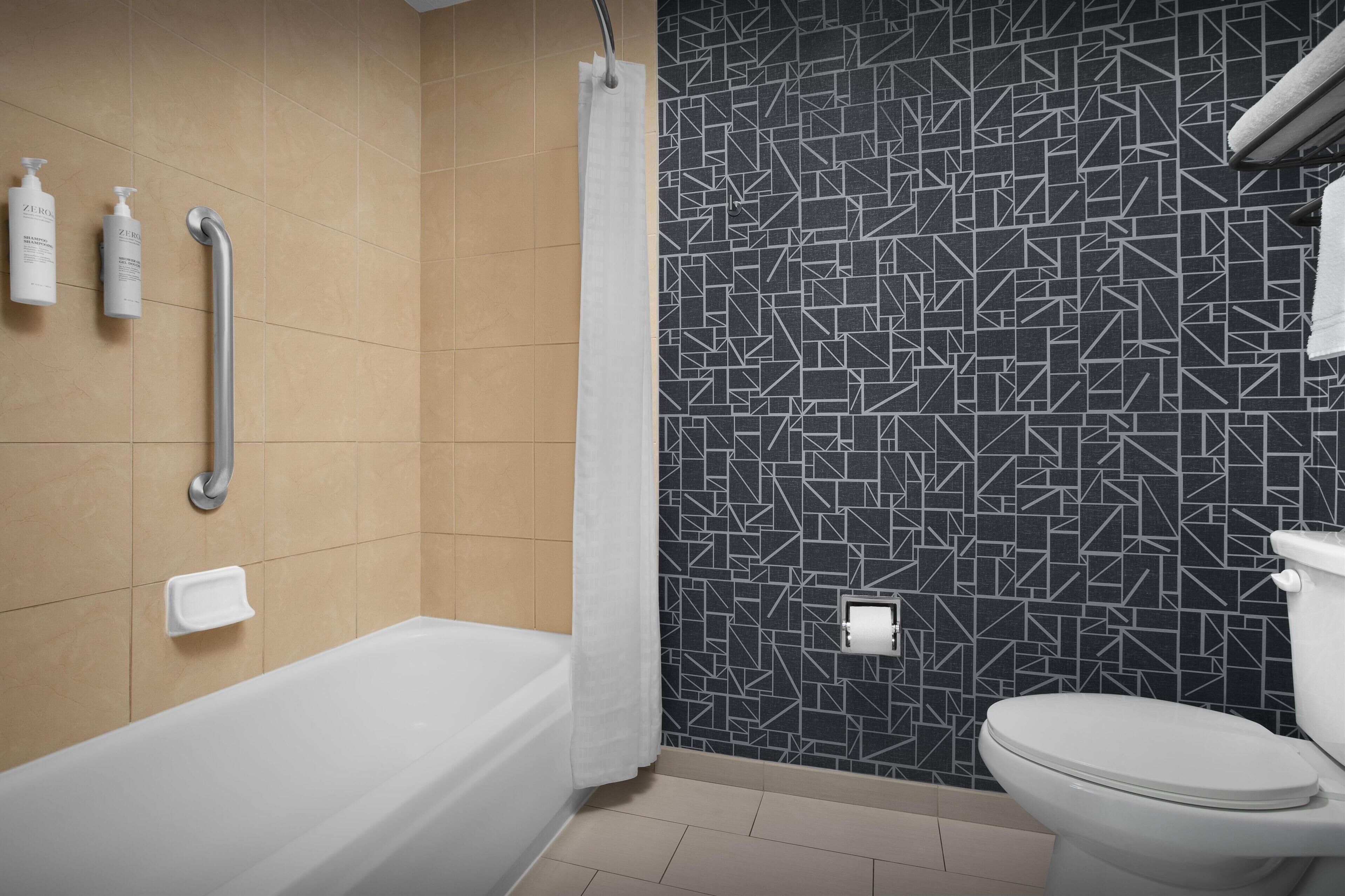 Ein Badezimmer mit Badewanne, Toilette und Duschbereich.