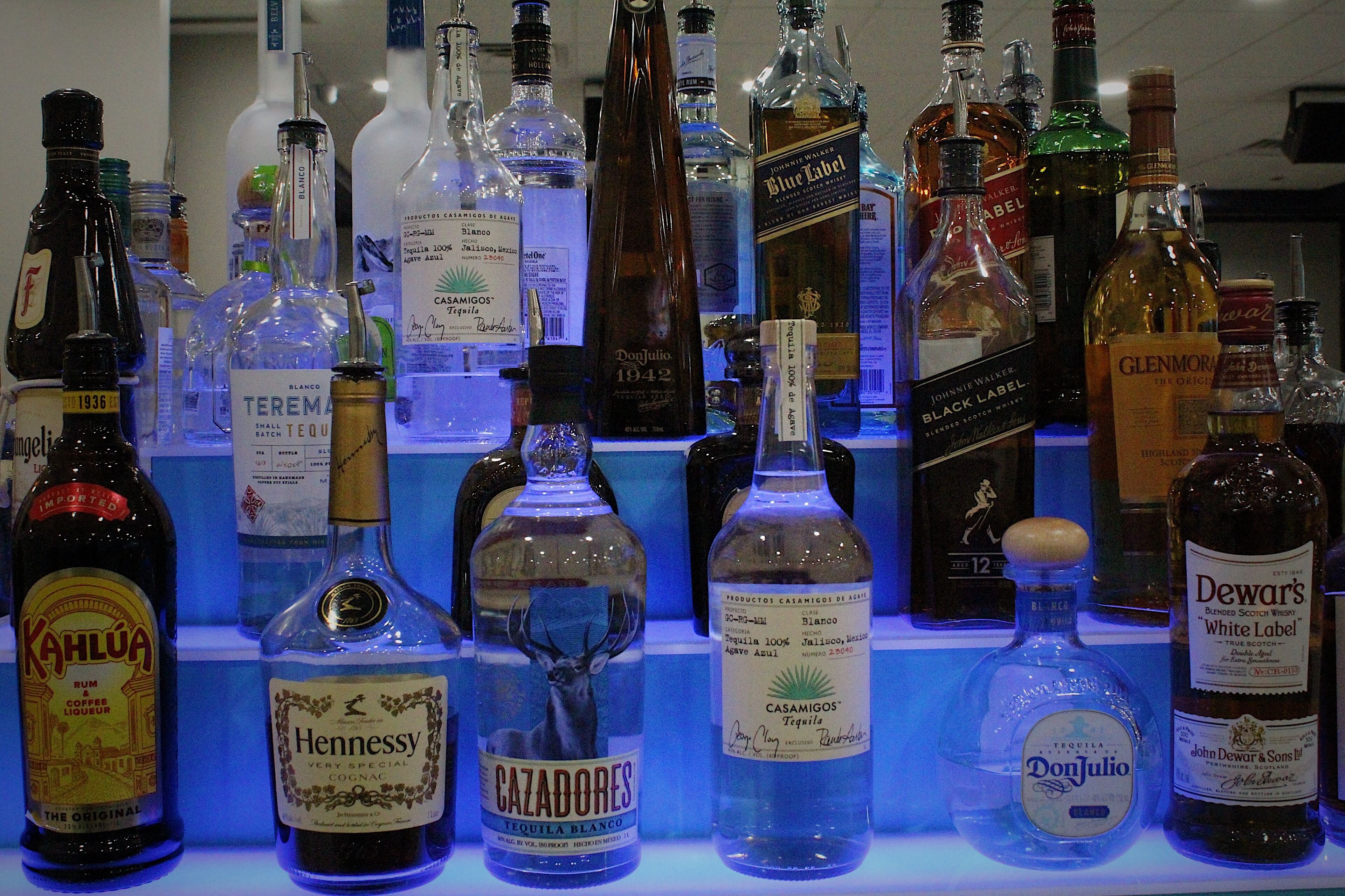 Une variété de bouteilles de spiritueux exposées sur des étagères.
