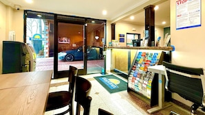 Un espace d’accueil avec un comptoir, des chaises, une porte d’entrée en verre, une enseigne Days Inn et une affiche « STOP à la traite des êtres humains ».