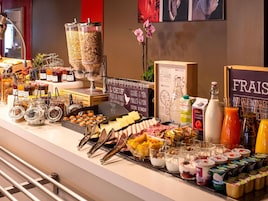 Un bufé con diversos alimentos, como frutas, quesos y bebidas.