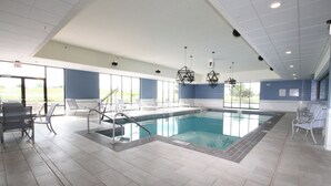 A swimming pool with a tiled deck, lounge chairs, and a view of the outdoors. - Holiday Inn Express Janesville - I-90 & US Hwy 14 by IHG (Janesville)