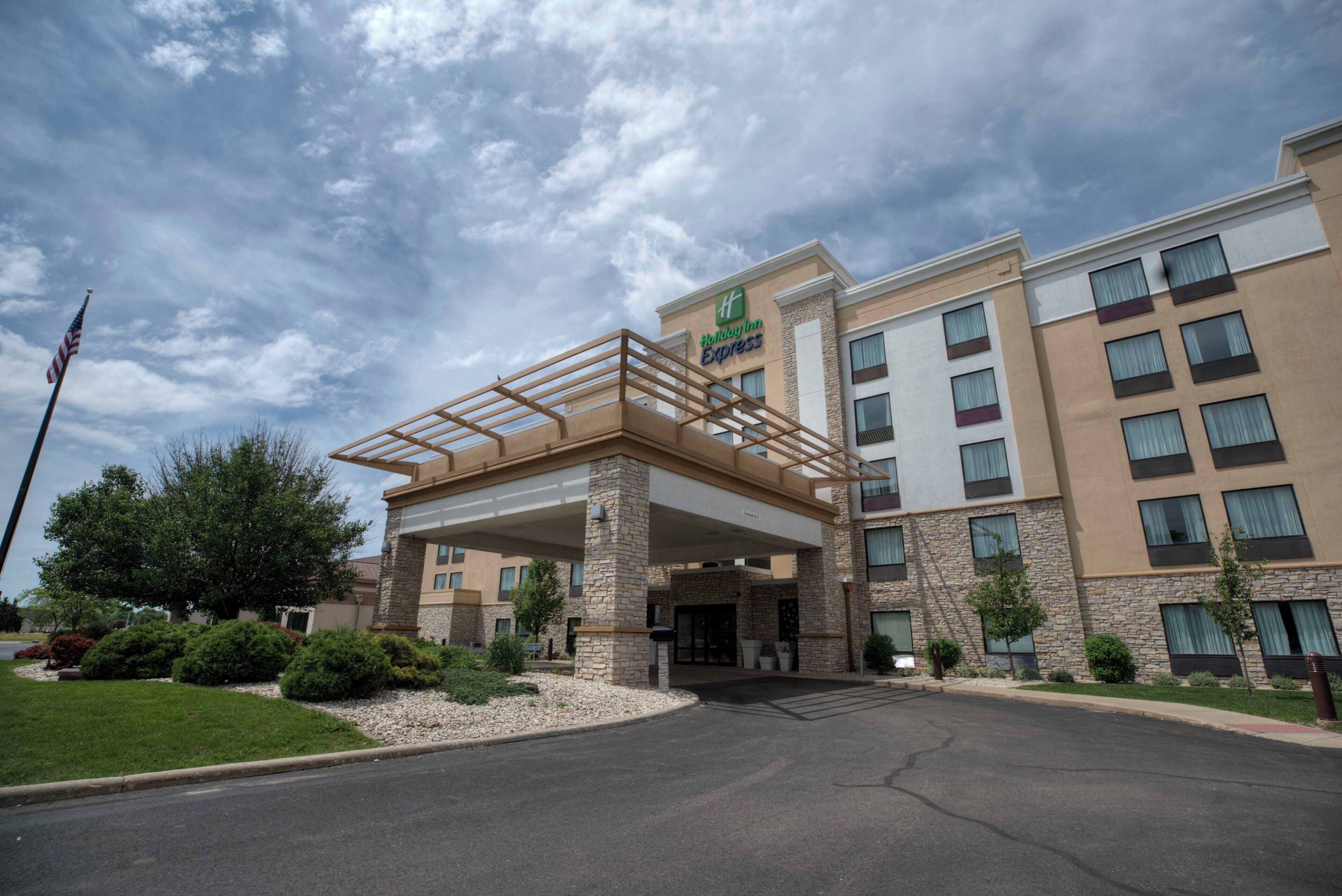 A Holiday Inn Express building with a covered entrance, stone facade, and multiple windows.