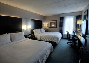 A hotel room with two beds, a desk with a computer, a chair, a desk lamp, and a window with curtains. - Holiday Inn Express Janesville - I-90 & US Hwy 14 by IHG (Janesville)