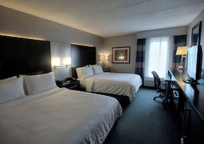 A hotel room with two beds, a desk with a computer, a chair, a desk lamp, and a window with curtains. - Holiday Inn Express Janesville - I-90 & US Hwy 14 by IHG (Janesville)