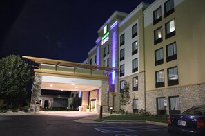A hotel entrance with a covered walkway, a parking lot, and a building with multiple windows. - Holiday Inn Express Janesville - I-90 & US Hwy 14 by IHG (Janesville)