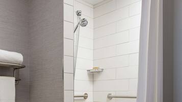 A modern bathroom with a shower, a towel rack, and a toilet.