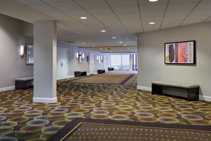 Enter a stylish lobby with patterned carpet, comfortable benches, and artwork-adorned walls.