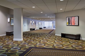 Enter a stylish lobby with patterned carpet, comfortable benches, and artwork-adorned walls.