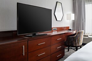 Relax in comfort with a large flat-screen TV, comfortable chair, and convenient bedside table.